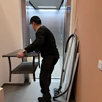 Der Umzugshelfer des umzugsunternehmen Badasov, die Umzugsgutes in den Aufzug transportiert.